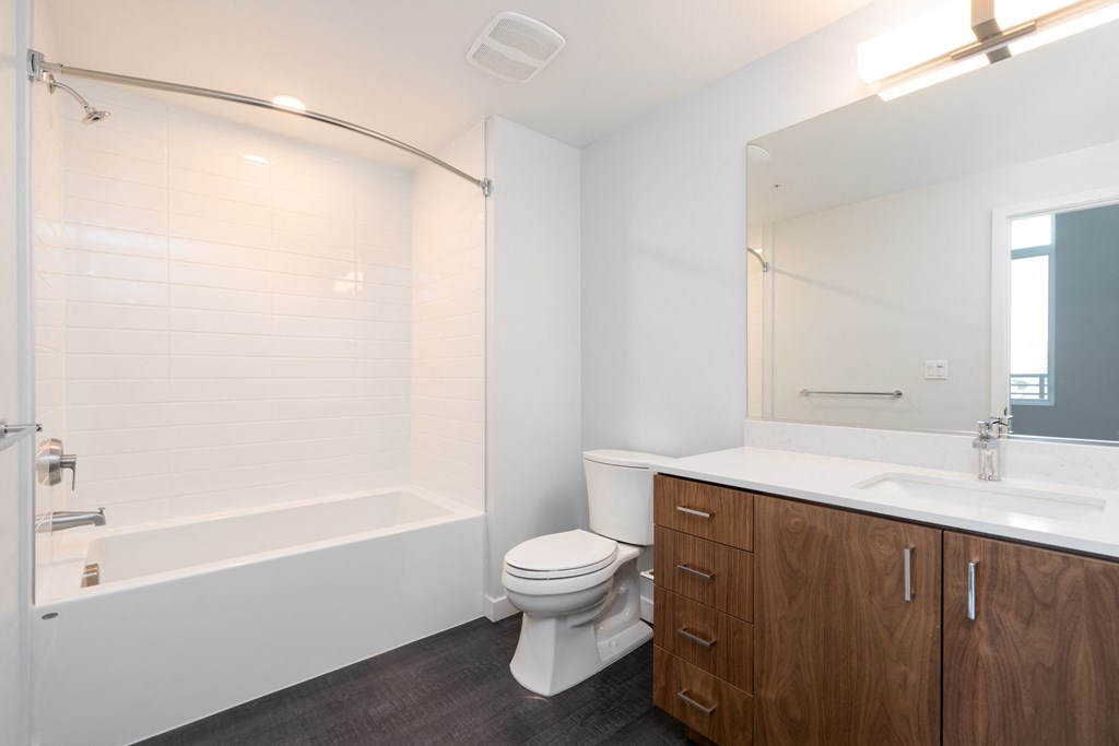 a bathroom with a toilet sink and shower and a mirror