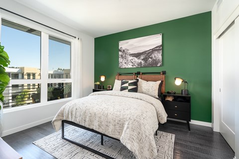 a bedroom with a bed and a green wall