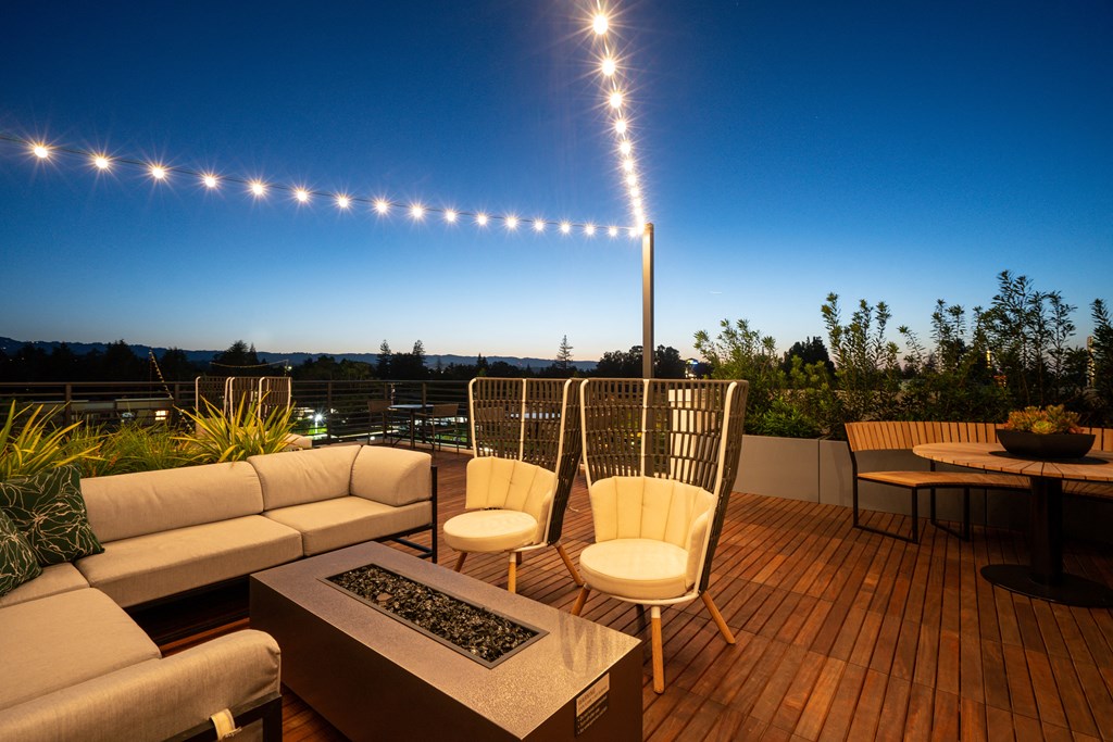 a roof deck with a couch and chairs and a table