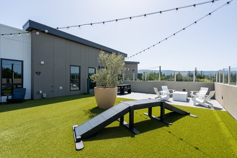 a roof terrace with a picnic table and chairs and a building