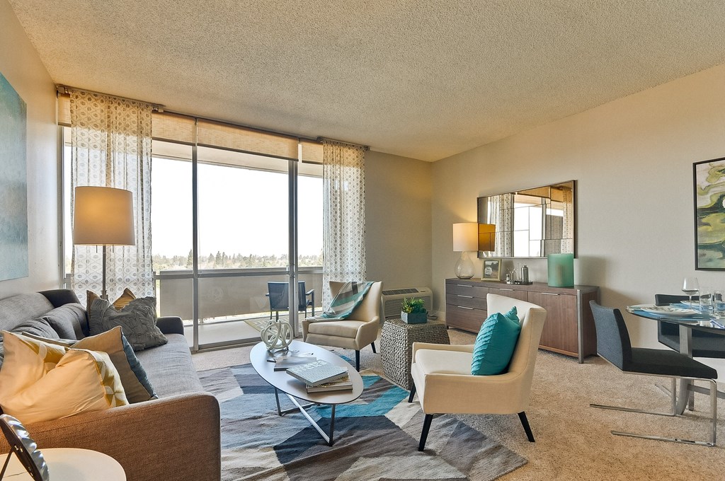 a living room with a large window and a table and chairs