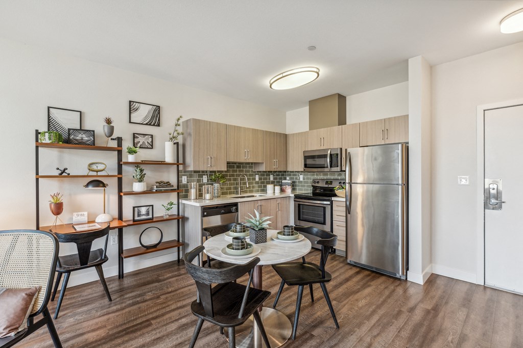 a kitchen with stainless steel appliances and a table and chairs