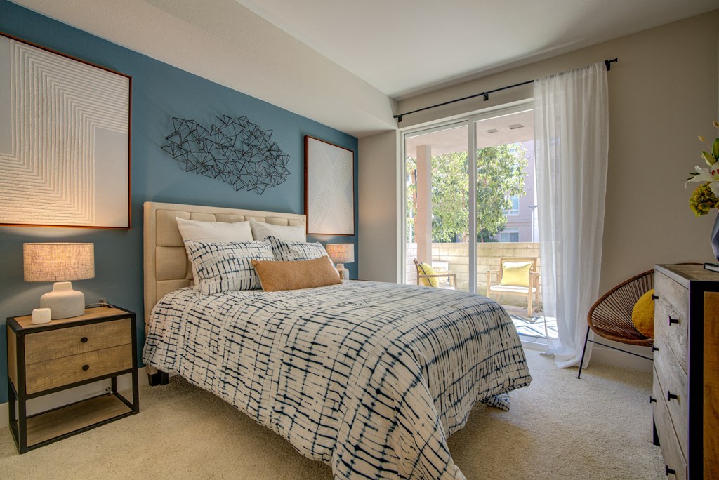 a bedroom with a bed and a sliding glass door to a balcony