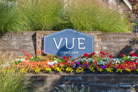 the sign for vue ascent on a stone wall next to colorful flowers