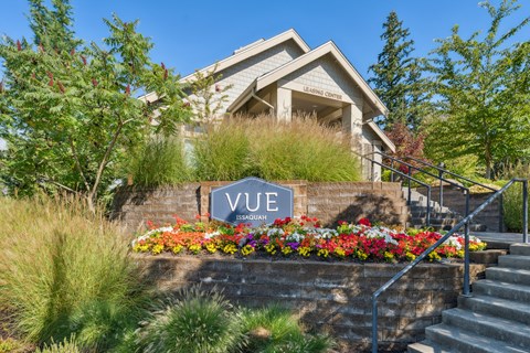 the facade of a house with a vue sign in front of a flower garden