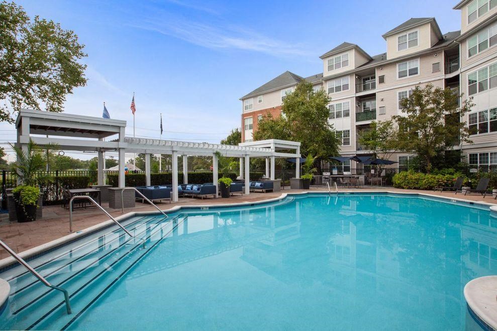 a swimming pool with an apartment building in the background