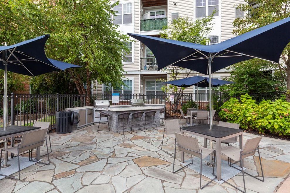 a patio with tables and chairs and umbrellas