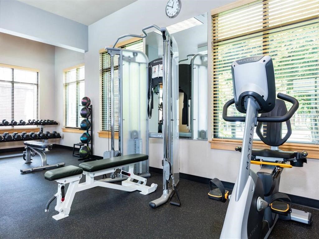a gym with various machines and weights in a room with a window