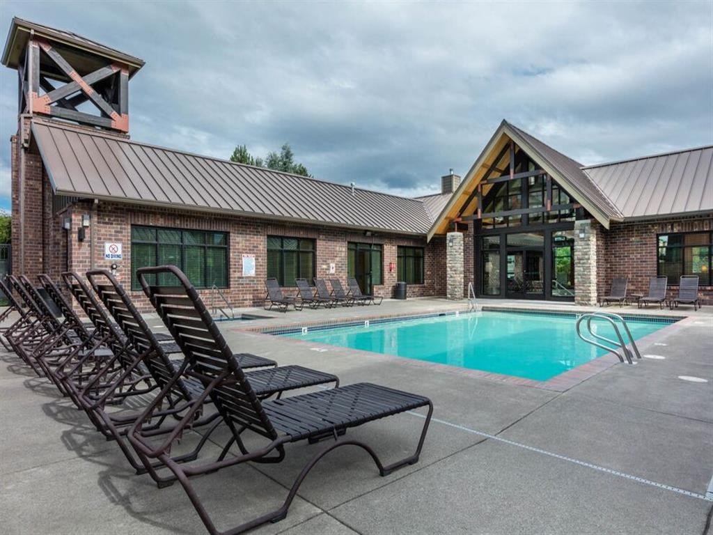 the pool is in front of a brick building with chairs