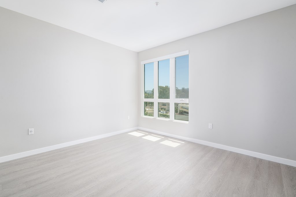 an empty room with white walls and a window