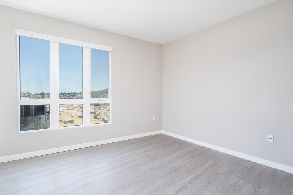 an empty room with white walls and wood floors