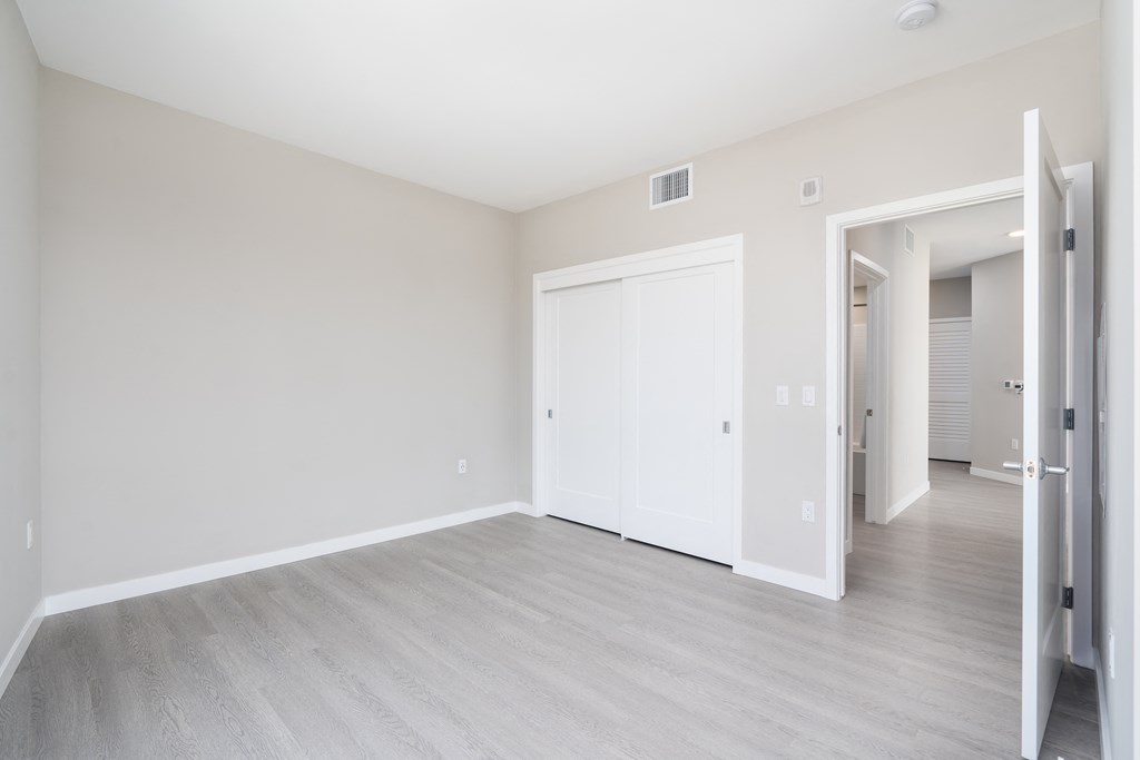 an empty living room with white walls and wood flooring