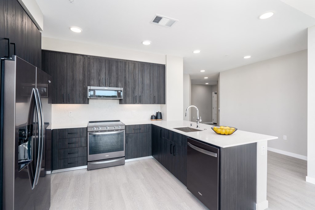 a kitchen with black cabinets and a white counter top