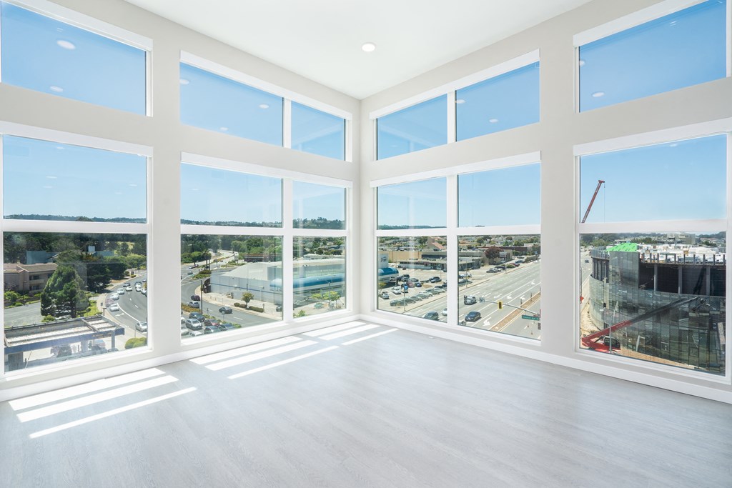 a living room with large windows and a view of a city