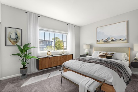 A bedroom with a large bed and a painting on the wall.