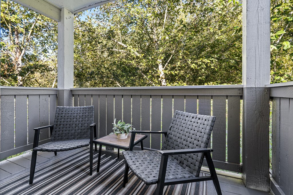 a patio with chairs and a table on a porch