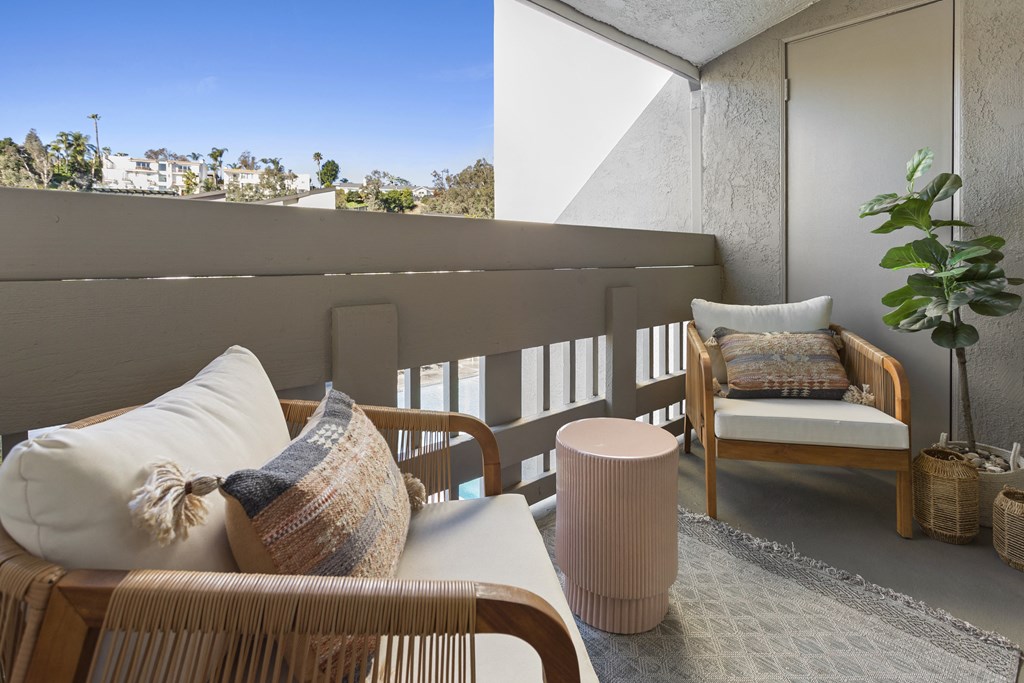 a living room with a couch and a chair on a balcony