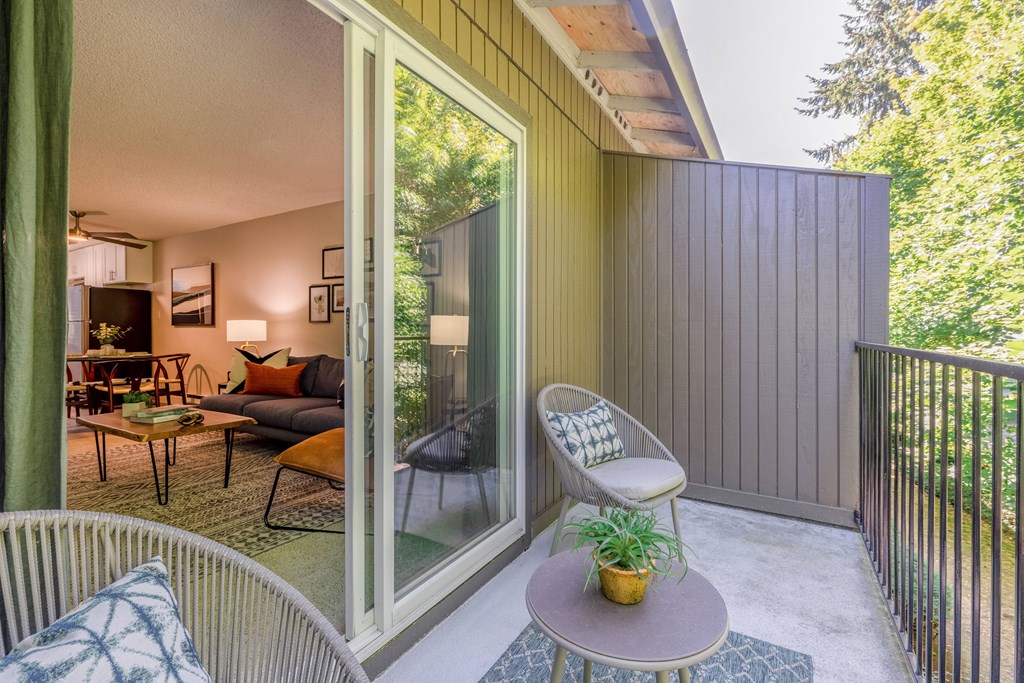 a balcony with a chair and a table and a living room