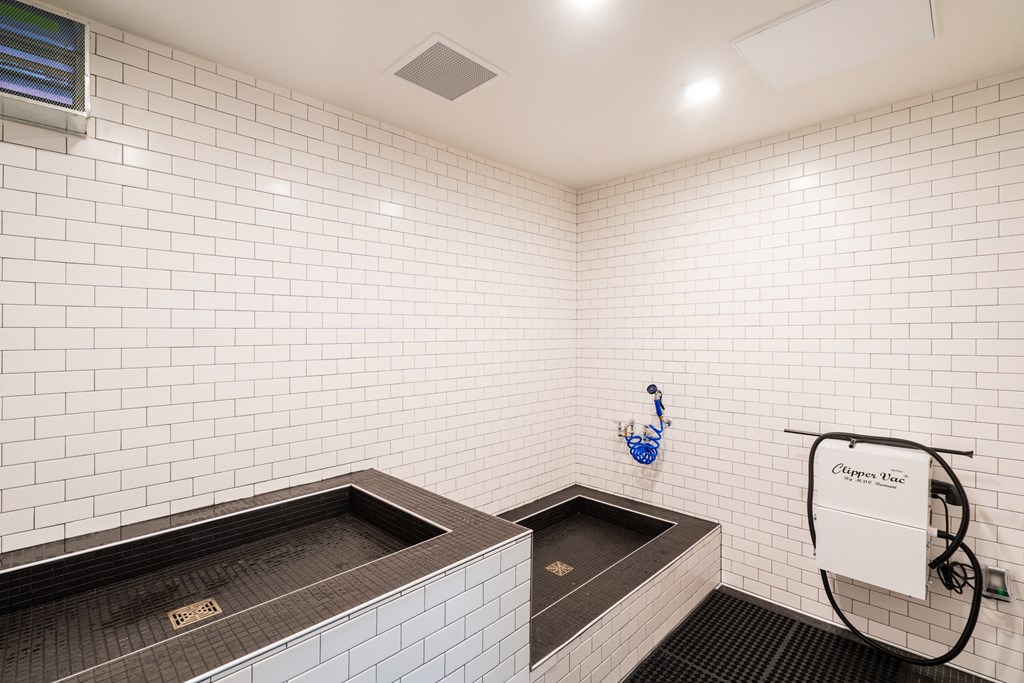 a white tiled bathroom with a tub and a sink