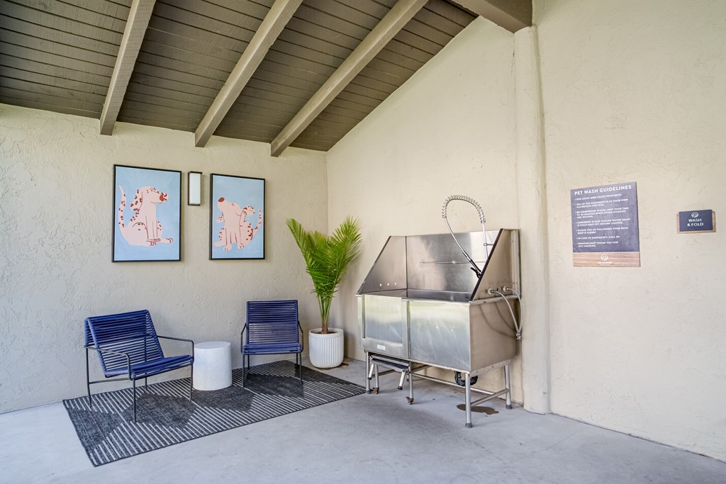 A room with a blue chair and a white table with a plant in it.
