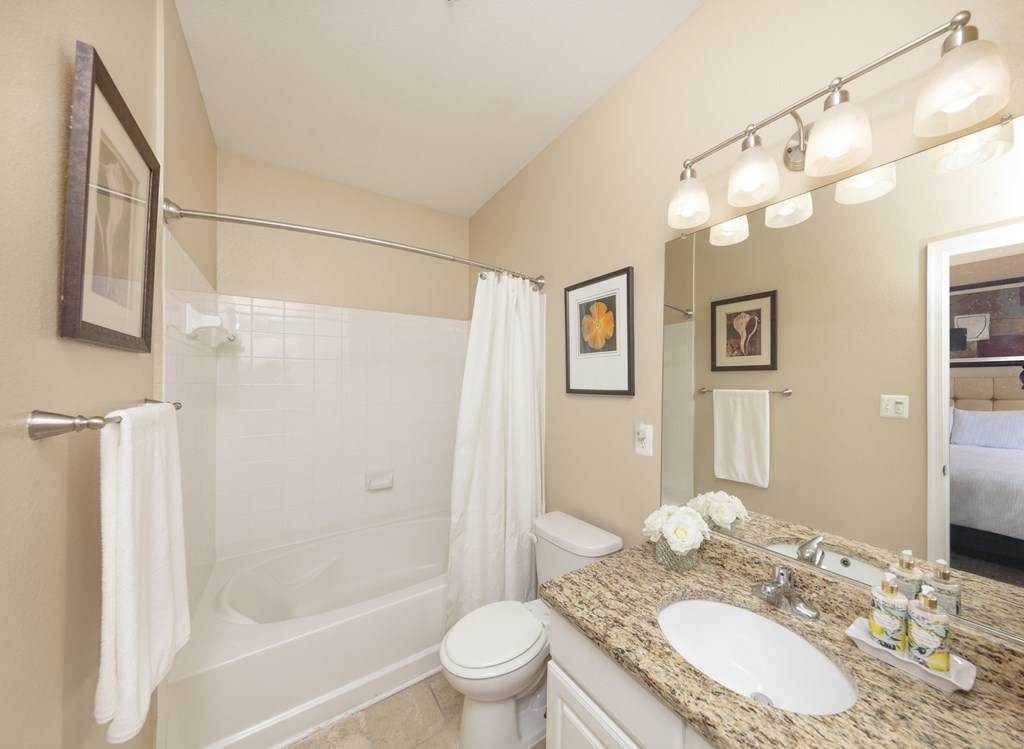 A bathroom with a white towel hanging on the tub.