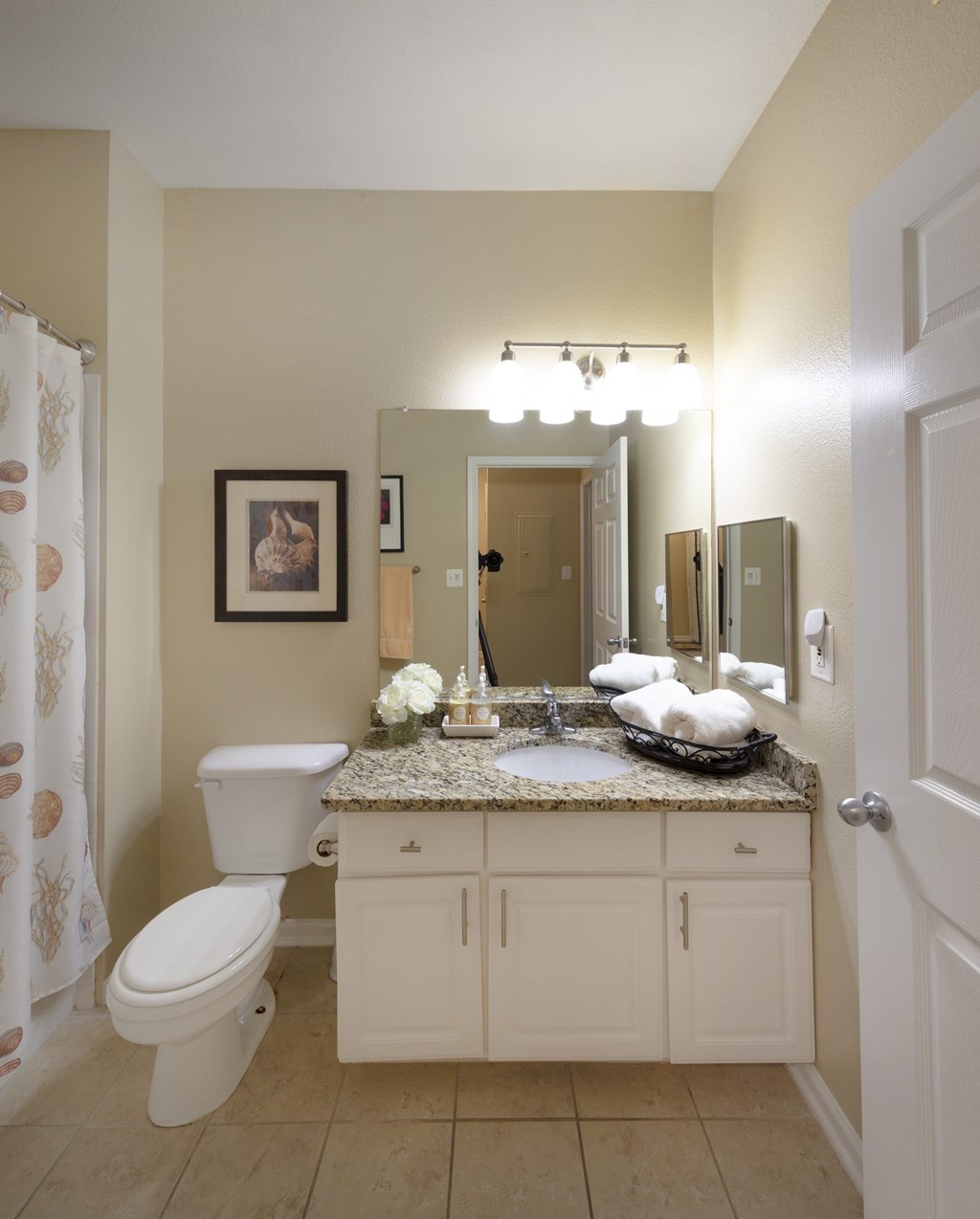 A bathroom with a toilet, sink, and mirror.