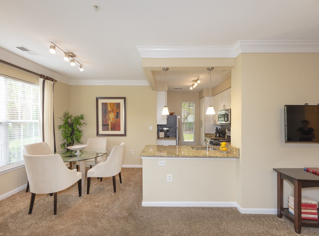 A dining room with a glass table and chairs.