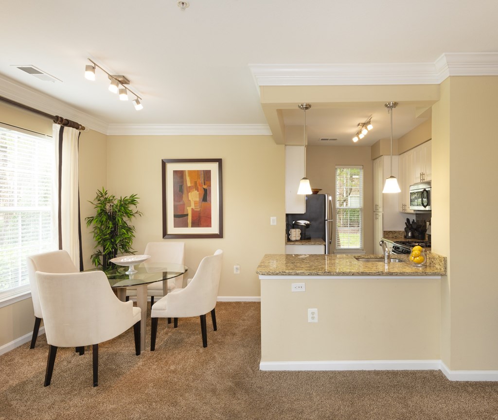 A dining room with a glass table and chairs.