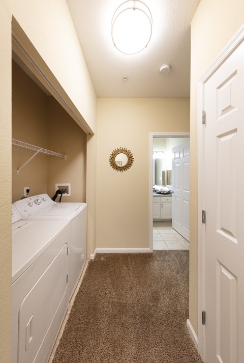A white bedroom with a round mirror on the wall.