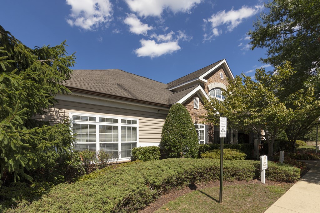 A house with a brown roof and a sign in front of it.