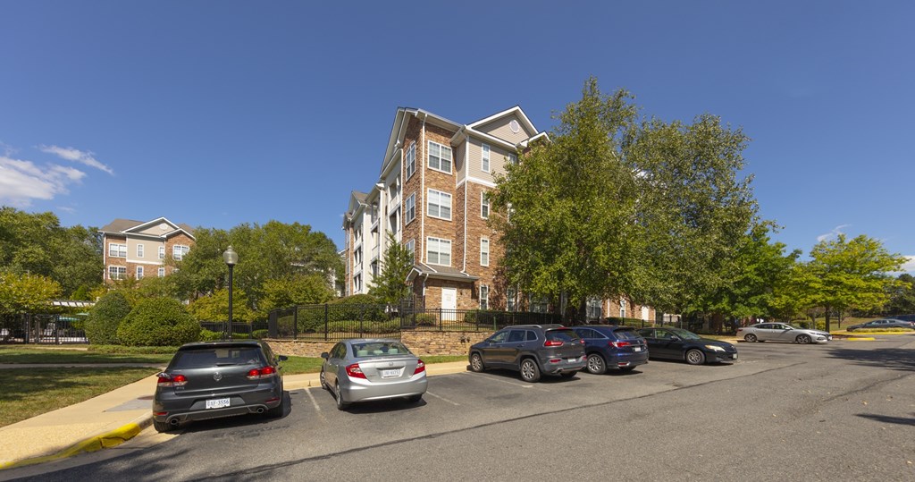 Cars parked in a parking lot in front of a building.