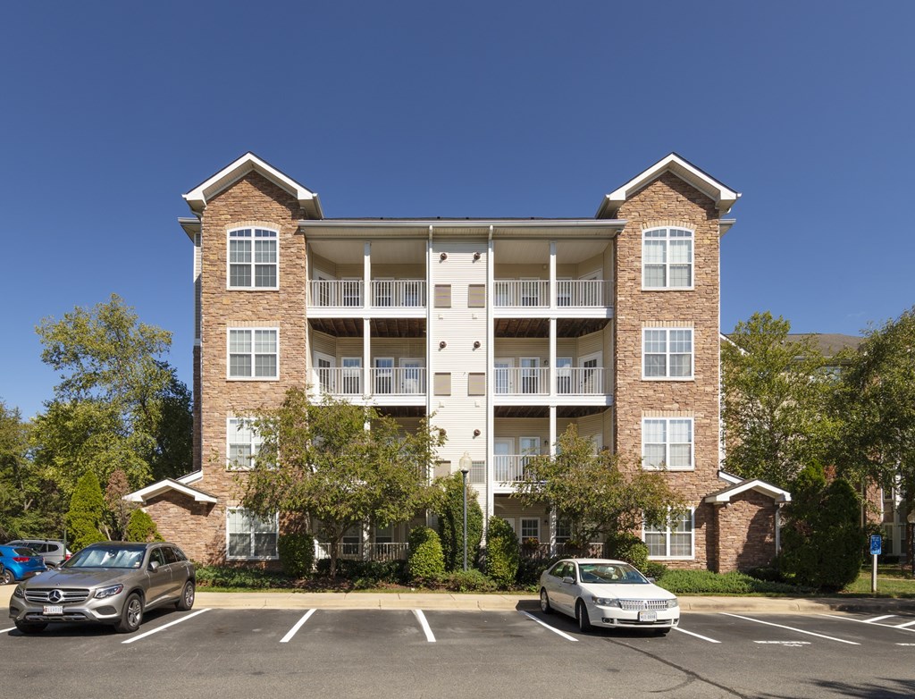 A large apartment building with a parking lot in front.
