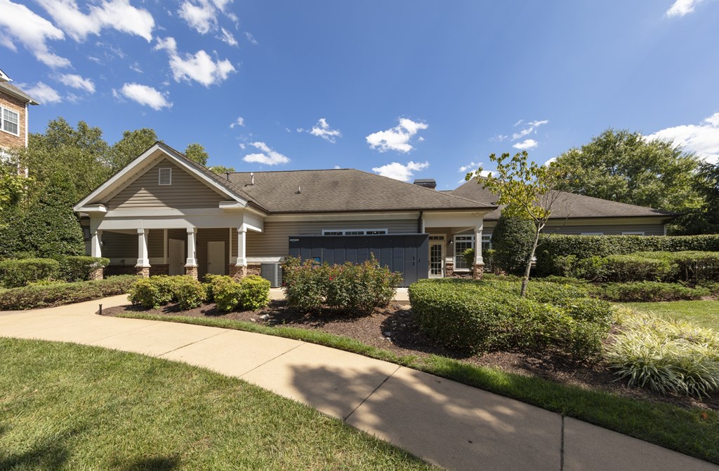 A house with a well-maintained lawn and a clear blue sky above.