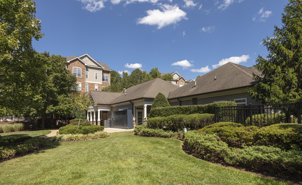 A house with a well-manicured lawn and trees in the background.