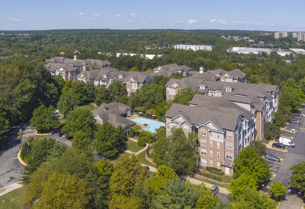 An aerial view of a large apartment complex surrounded by trees.