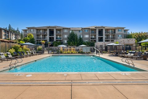 a swimming pool with an apartment building in the background