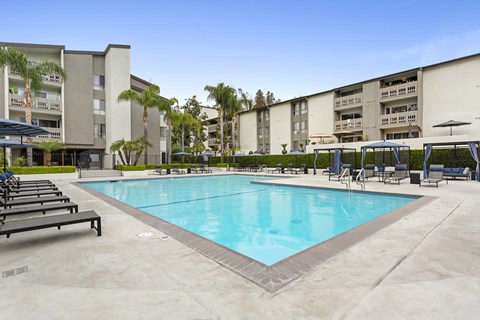 A large swimming pool in front of apartment buildings.