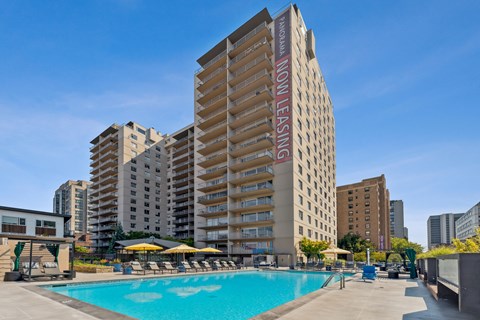 a swimming pool in front of a tall apartment building