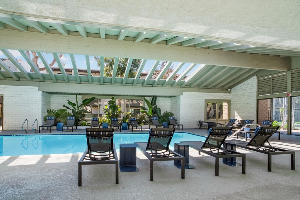 A pool with chairs and a table in the middle of it.