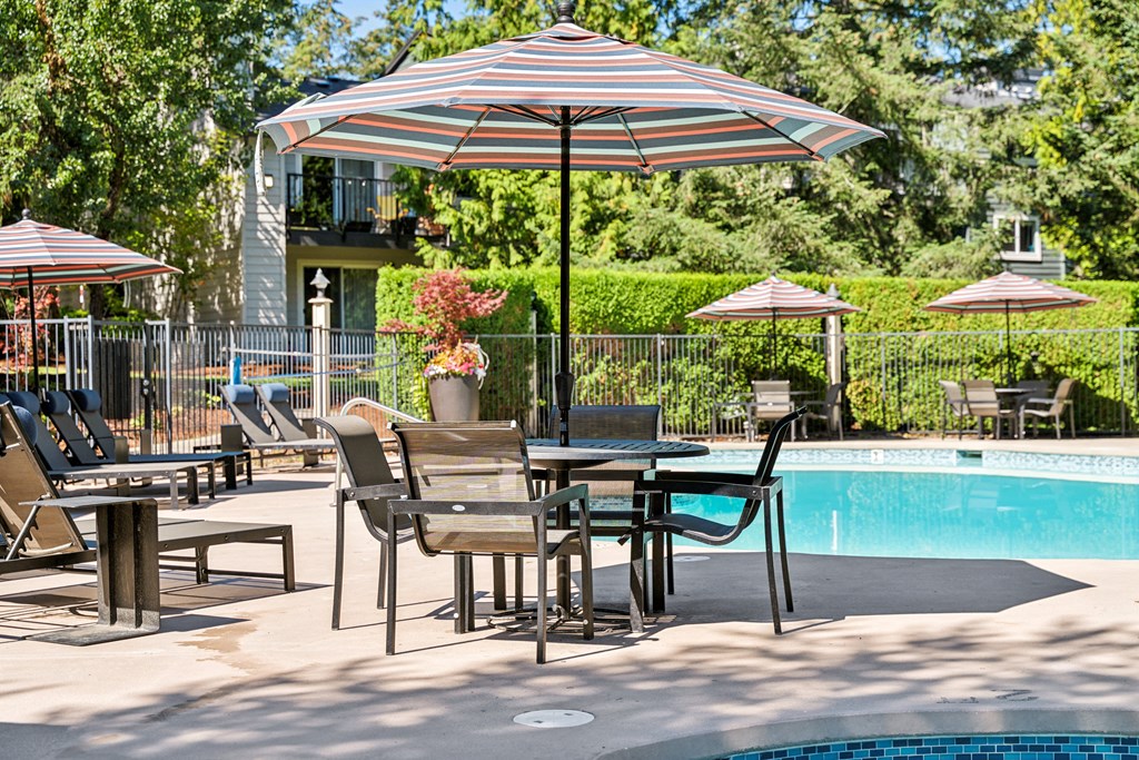 a pool with tables and umbrellas next to a swimming pool