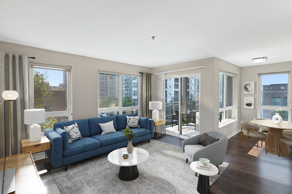 a living room with a blue couch and a white coffee table with two chairs