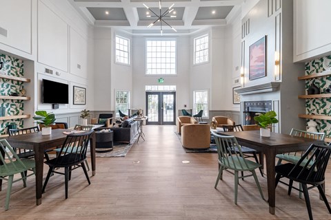 a large living room with tables and chairs and a fireplace