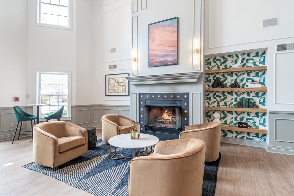 a living room with chairs and a fireplace