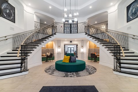 a living room with a spiral staircase and a green couch