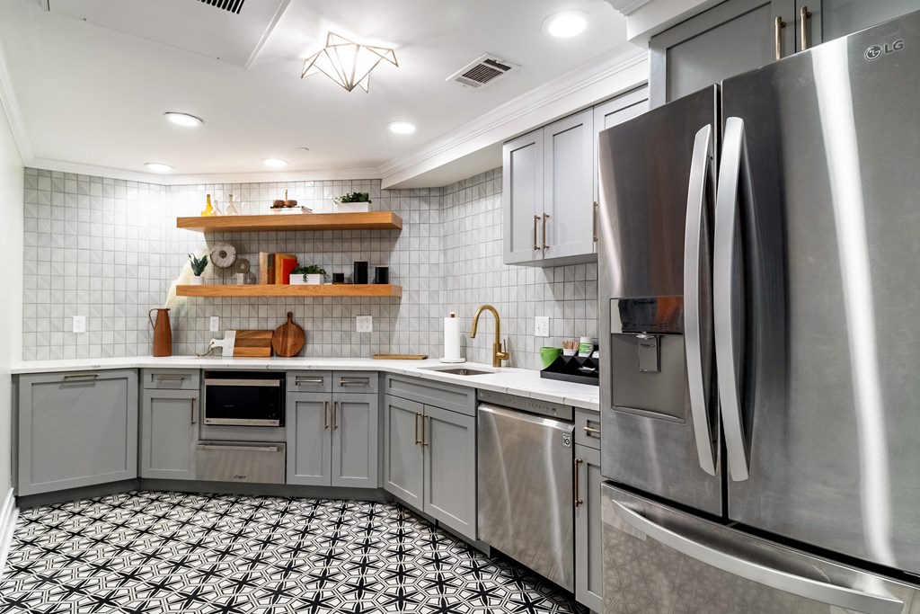 a kitchen with gray cabinets and stainless steel appliances
