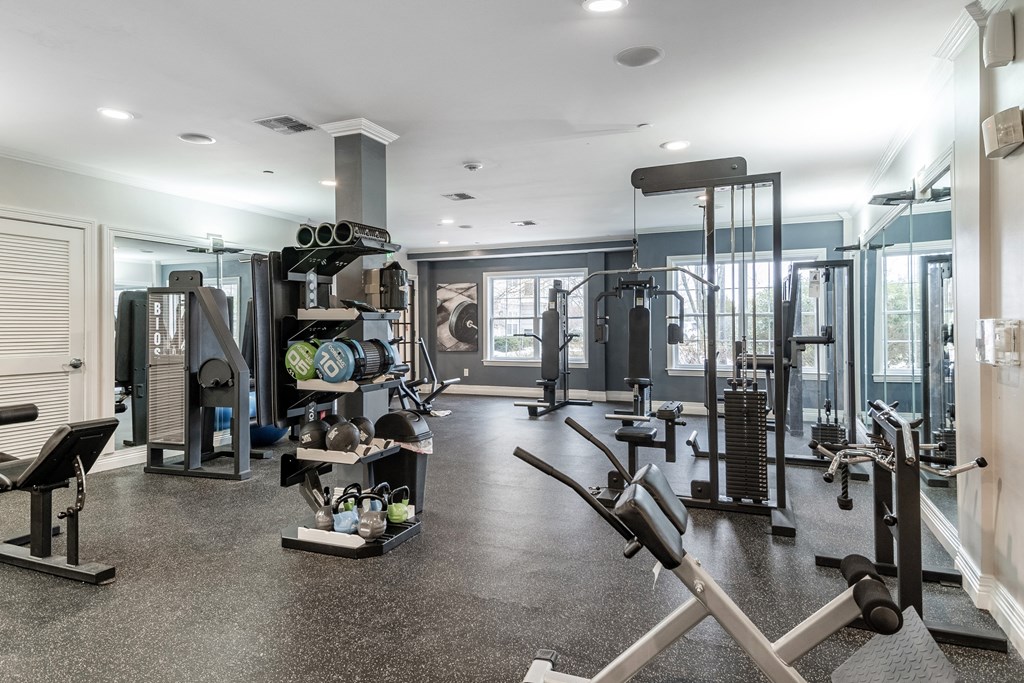 a home gym with weights and cardio equipment and a window