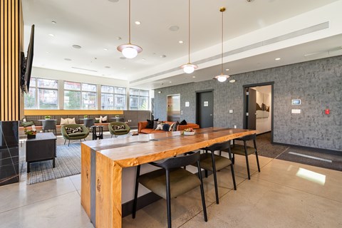 A modern dining room with a long wooden table and black chairs.