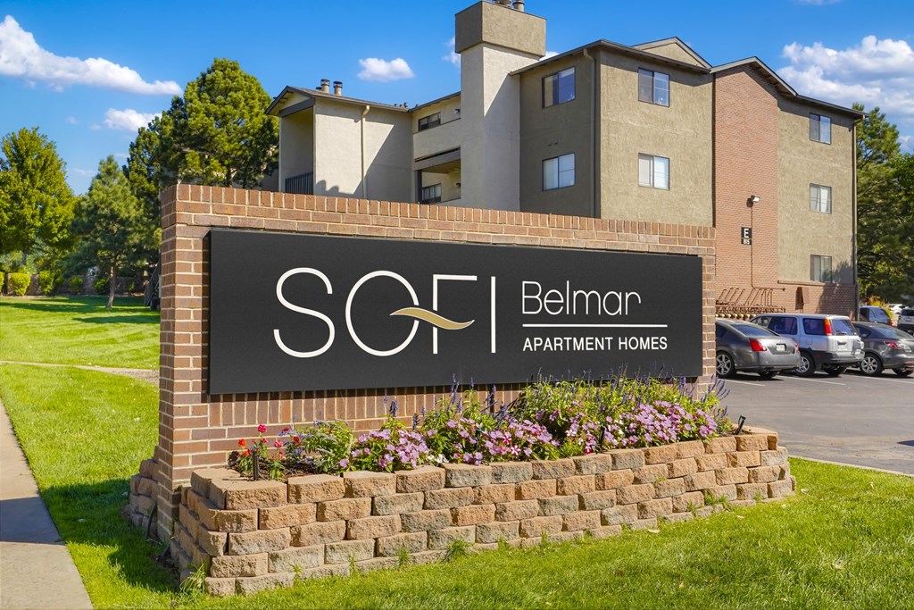 a sign apartments in front of a parking lot