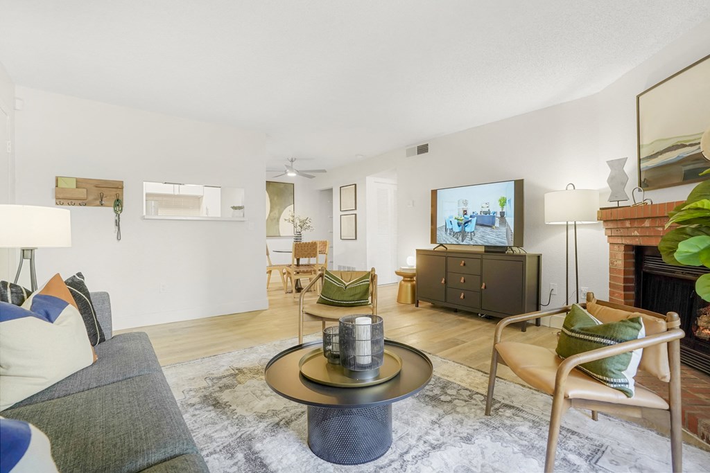 a living room with a couch and chairs and a tv