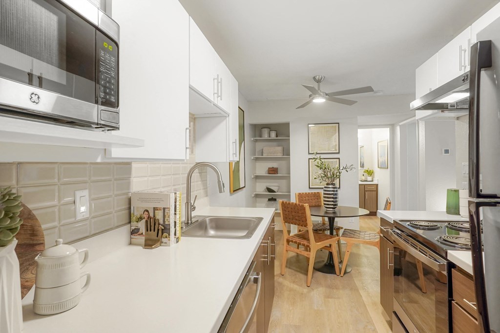 a kitchen with a white counter top and a sink